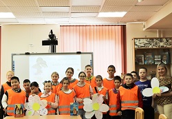 группа детей показывают три большие ромашки из бумаги